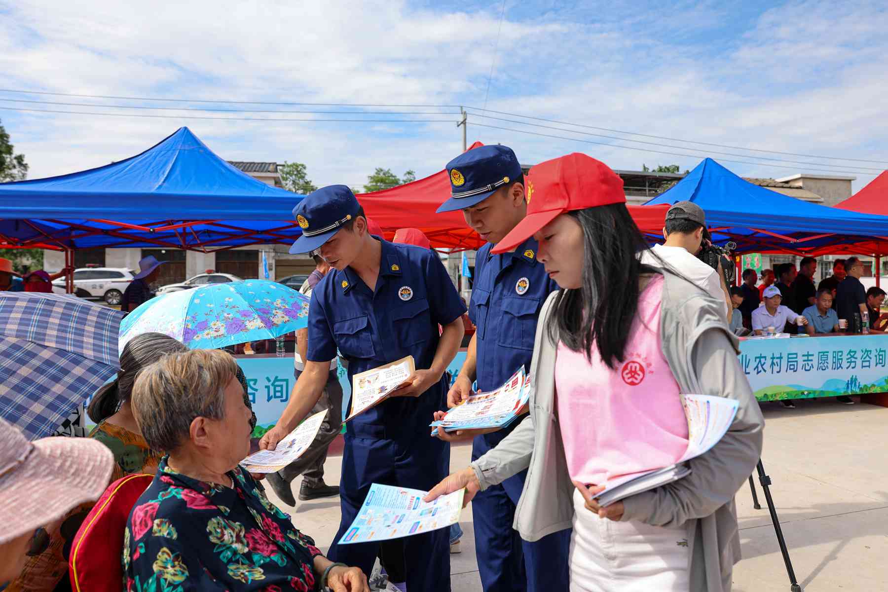 消防宣傳員與志願者向村民講解消防知識（單位供圖)