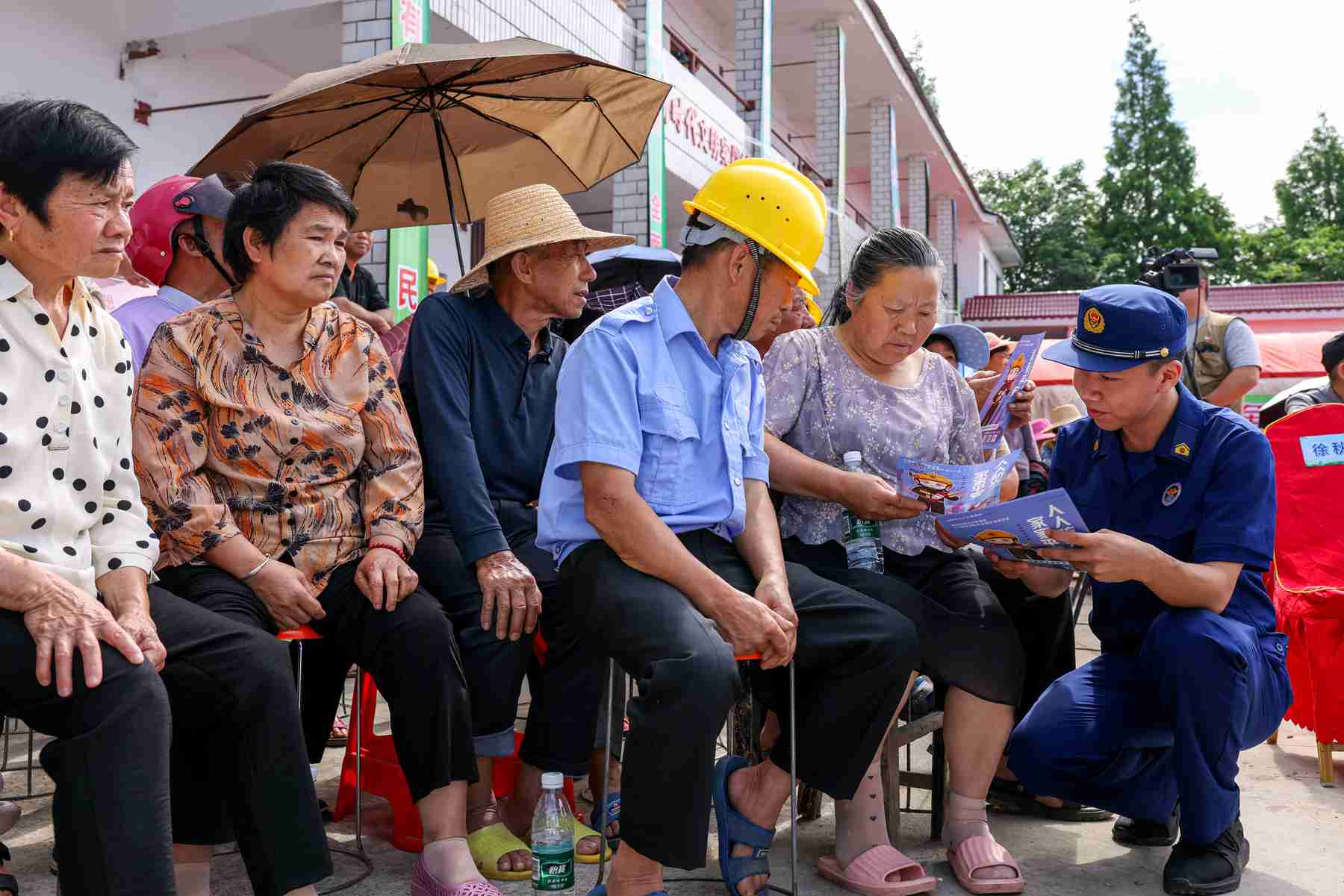 消防宣傳員與志願者向村民講解消防知識（單位供圖)