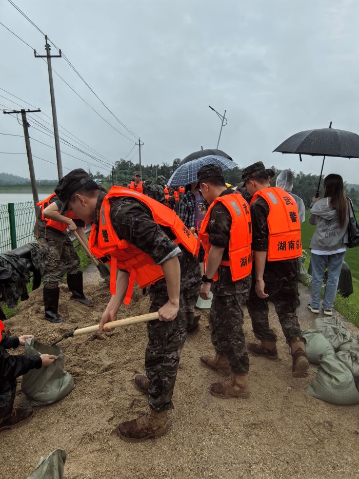 飄峰水庫發生管涌，武警長沙支隊官兵填裝沙袋封堵管涌。單位供圖