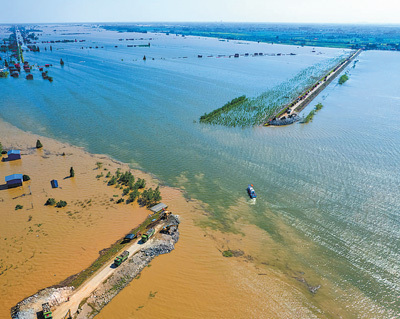 7月6日，在湖南省岳阳市华容县团洲垸洞庭湖一线堤防决堤现场，抢险队伍进行堵口作业。新华社记者 陈思汗摄