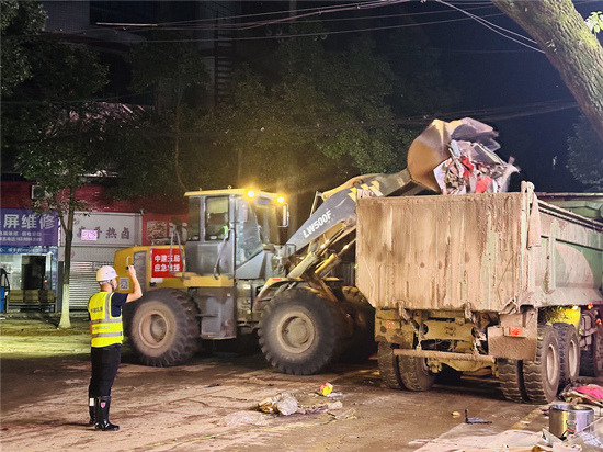铲车正在运输路面杂物。受访单位供图