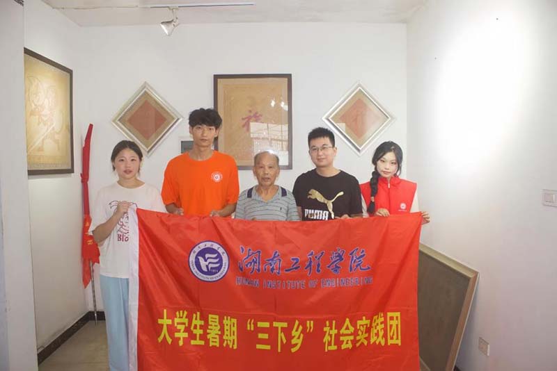 实践团与肖体贵合影留恋。受访单位供图