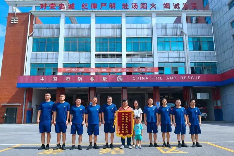 消防救援人员与送锦旗的群众合影留念。单位供图