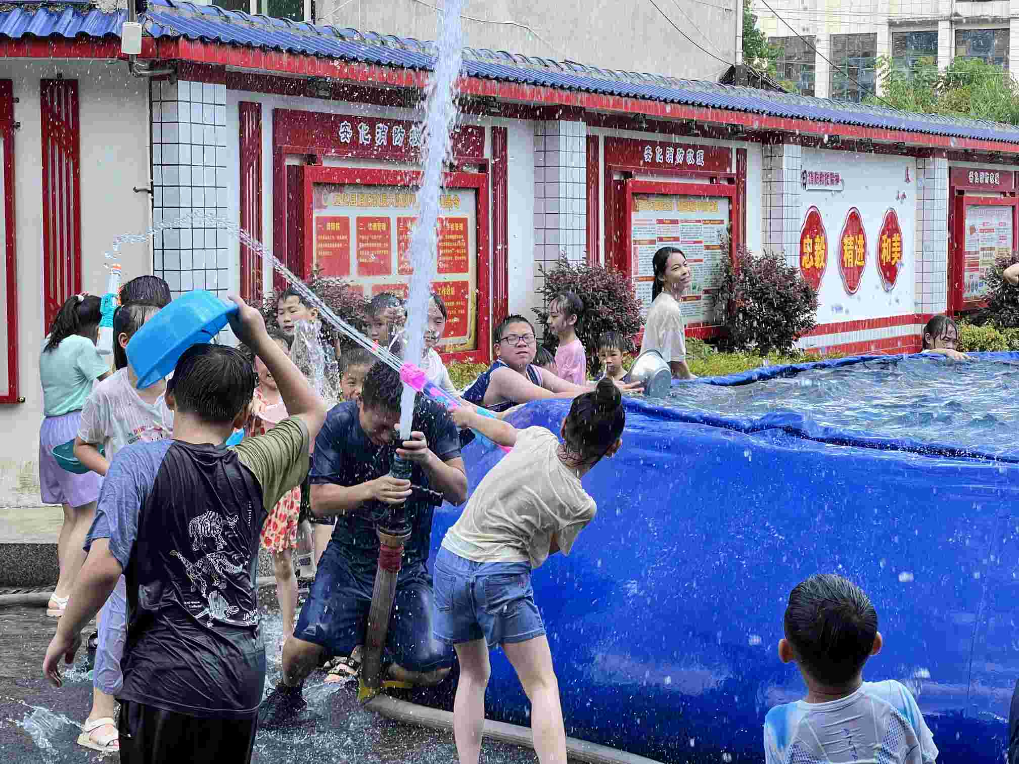 消防员与小朋友们正在开展“泼水大战”互动活动（单位供图）