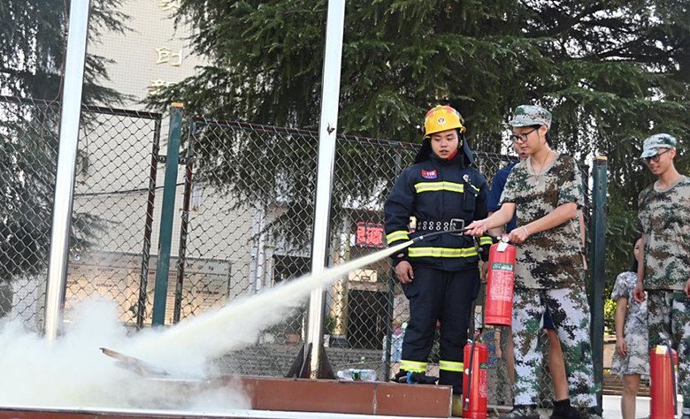 消防员教学生使用灭火器。城步消防供图