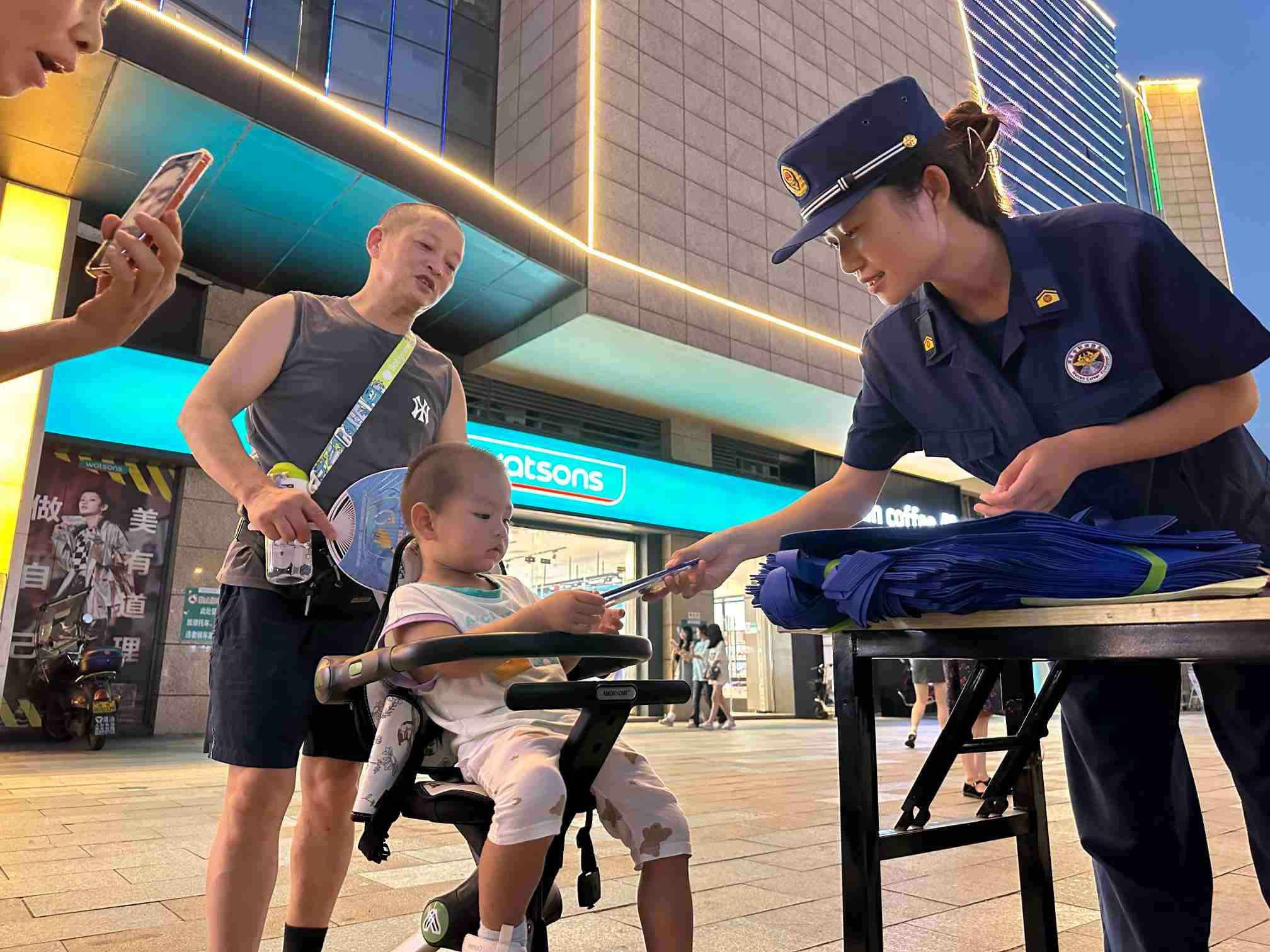 消防宣传员在摆台设点向向群众讲解消防安全知识（单位供图）