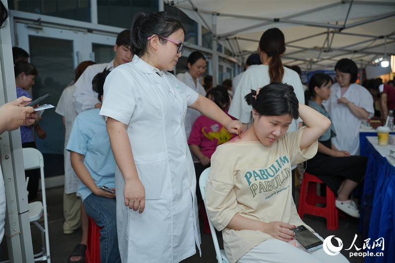 市民在中医指导下刮痧。人民网记者 林洛頫摄