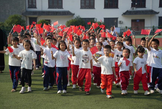 少年儿童舞动五星红旗祝福新中国成立75周年。孙芳华摄