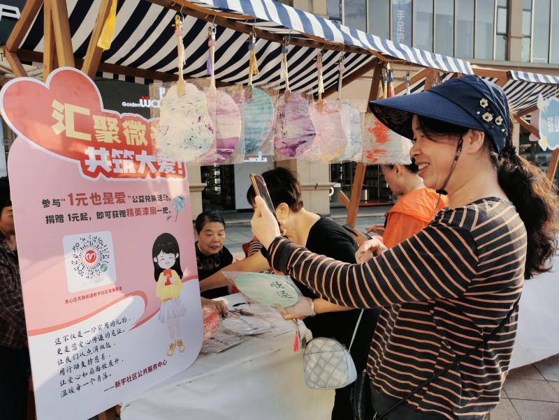 重阳沉浸式体验区居民扫码领取公益漆扇。单位供图