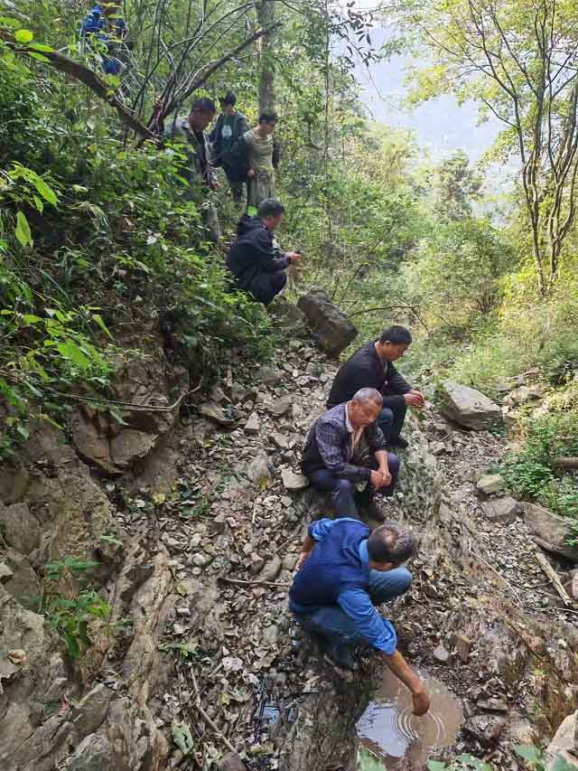 柑子坪村包村民警向圣国联合驻村工作队进山为百姓寻找水源。受访单位供图