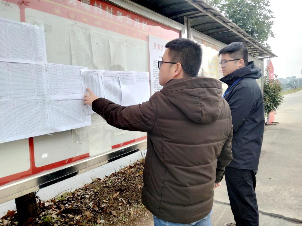 纪委工作人员在龙头嘴村了解该村低保名单公示情况。贾婷摄