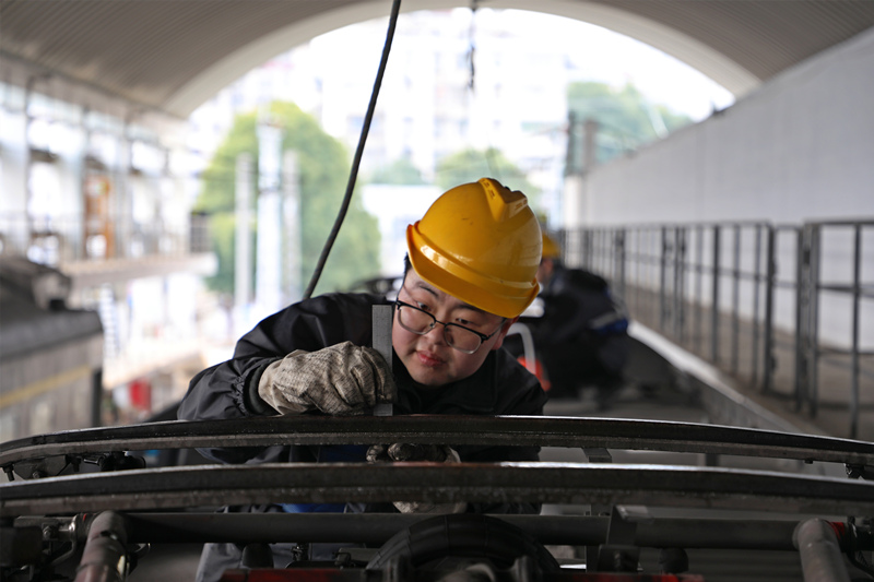 動集動車組地勤機械師在檢測受電弓碳滑板厚度。譚軼夫攝