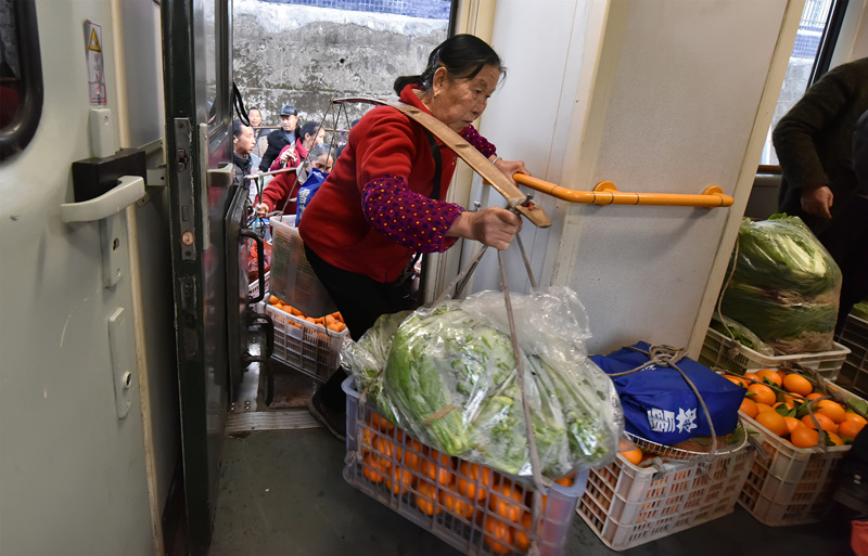 早上，当地村民挑着农产品在锦和站上车。胡盛平摄