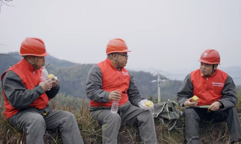 电力员工在野外巡检吃饭。受访单位供图