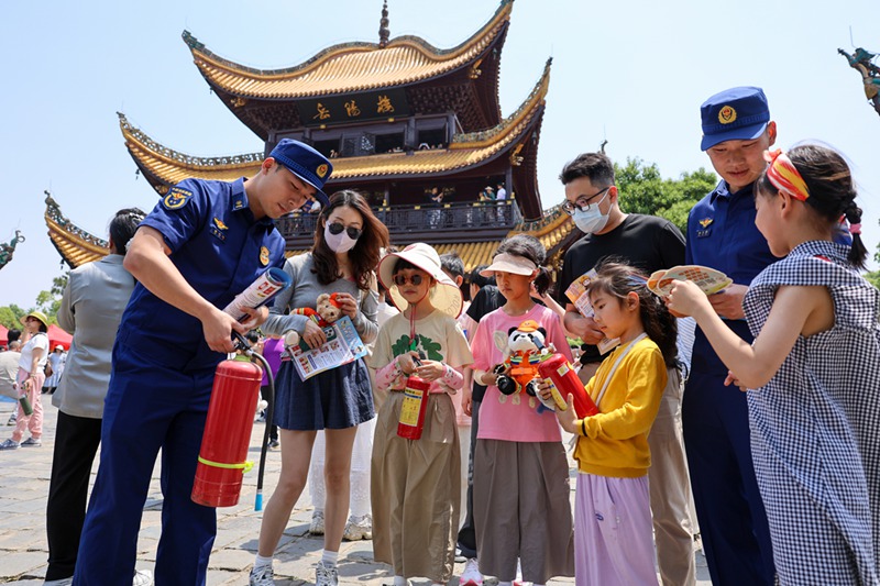 消防宣传员为游客讲解灭火器的使用方法（单位供图）