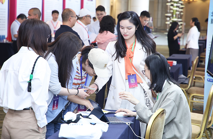 参会嘉宾在展位前了解企业情况。主办方供图