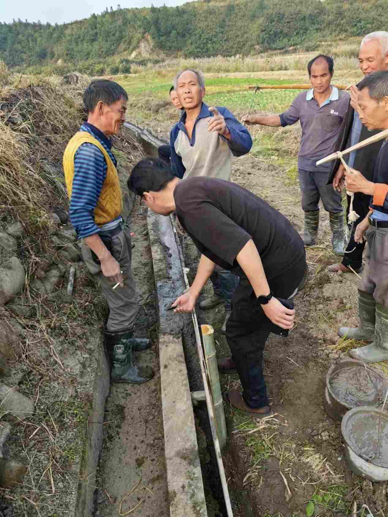 驻村工作队对修建水渠进行实地指导。学校供图