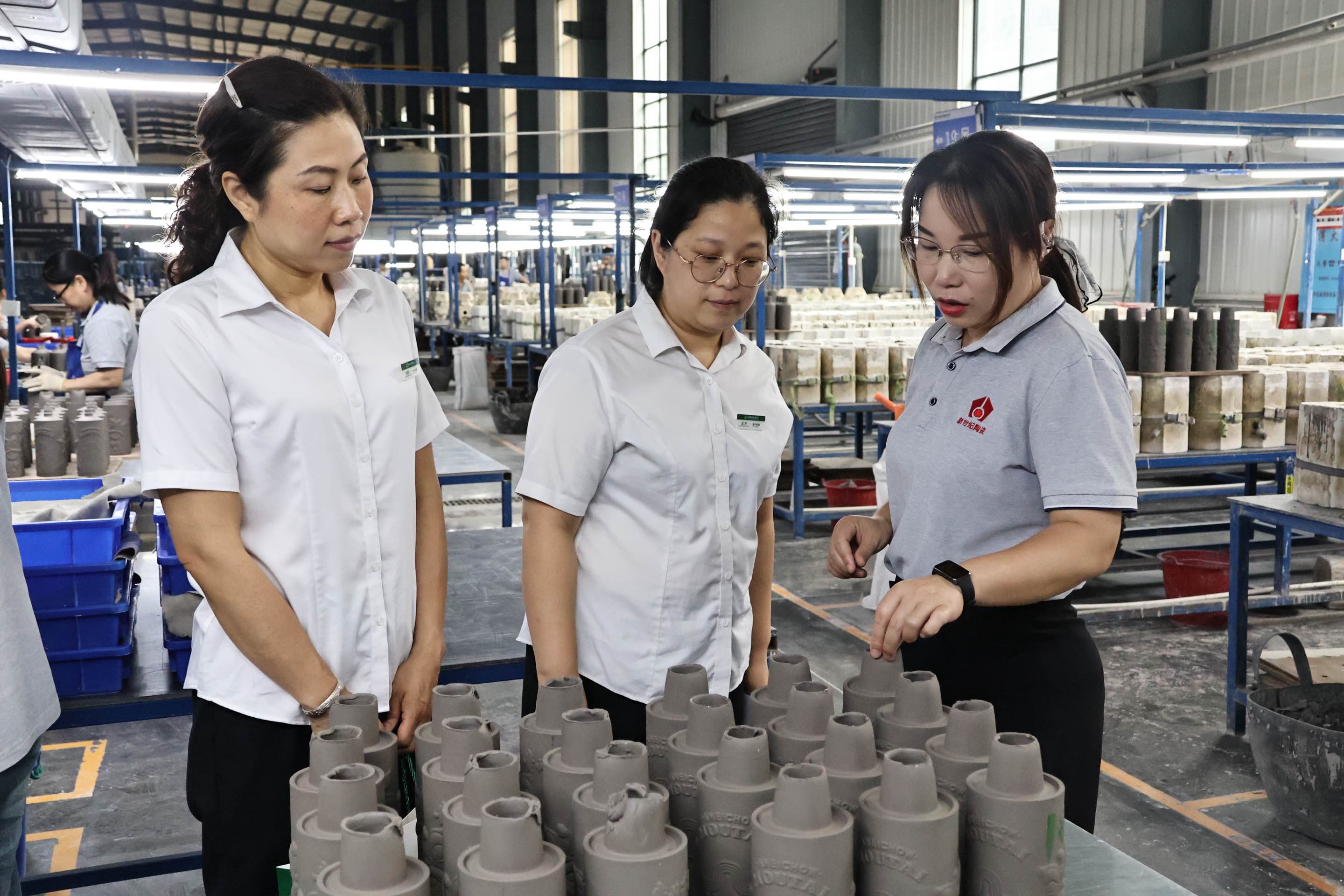 新世纪陶瓷员工为醴陵支行工作人员介绍生产情况。谢语欣摄
