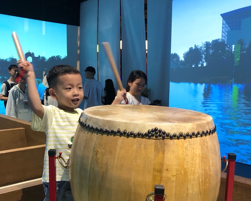 小朋友体验燕尾龙舟竞技场景。谢语欣摄