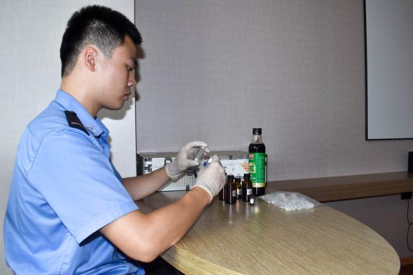 实践团成员对成品酱油进行现场取样检测。单位供图