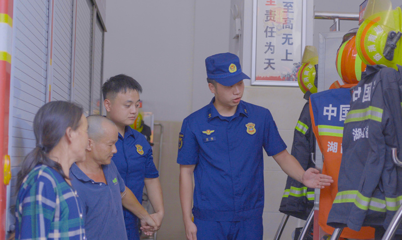 消防员为孙力母子介绍消防装备。吴翰林摄