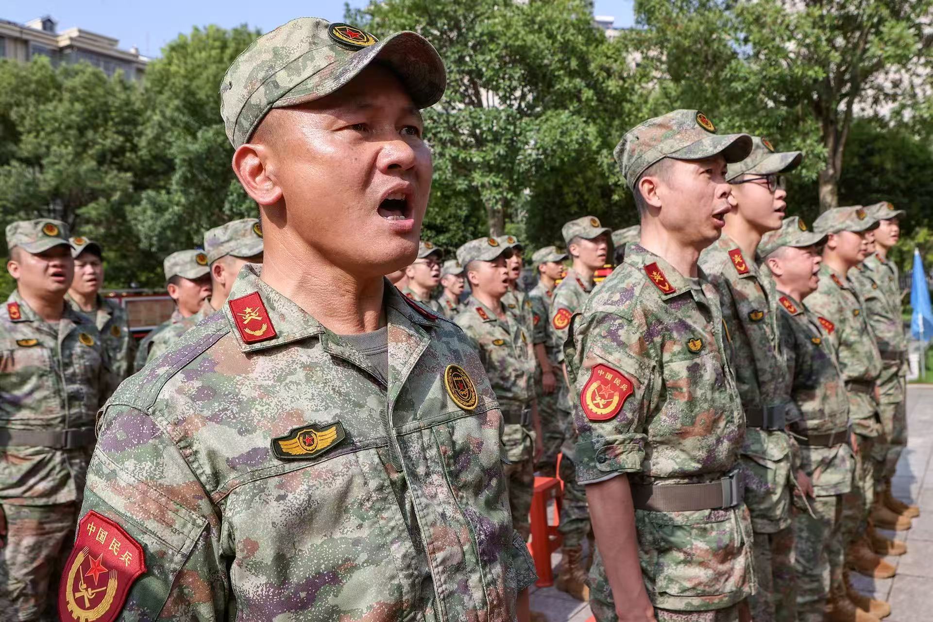 县人武部现役军人和民兵在活动现场合唱《咱当兵的人》。陈卫平摄