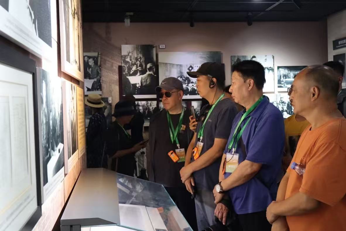 纪念馆内，采访团与游人细听讲解。谌与为摄