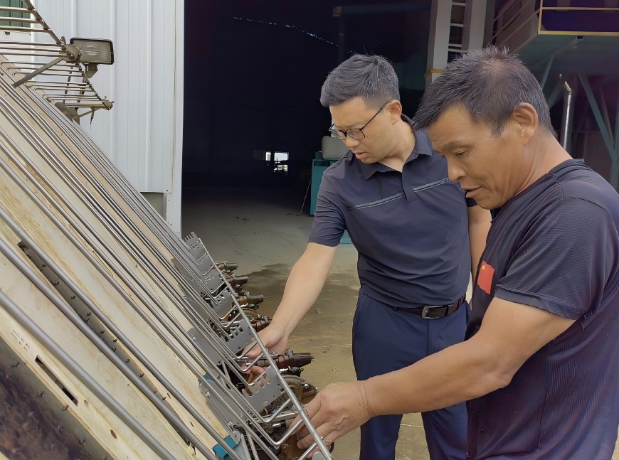 旦增平措（左）在合作社查看農機情況。單位供圖