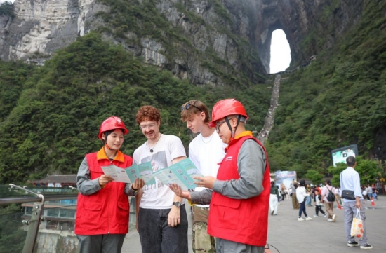 工作人员在天门山景区向外国游客讲解安全用电知识。受访单位供图