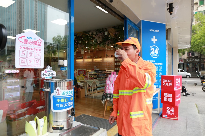 环卫工人在“爱心驿站”门口喝水。受访单位供图