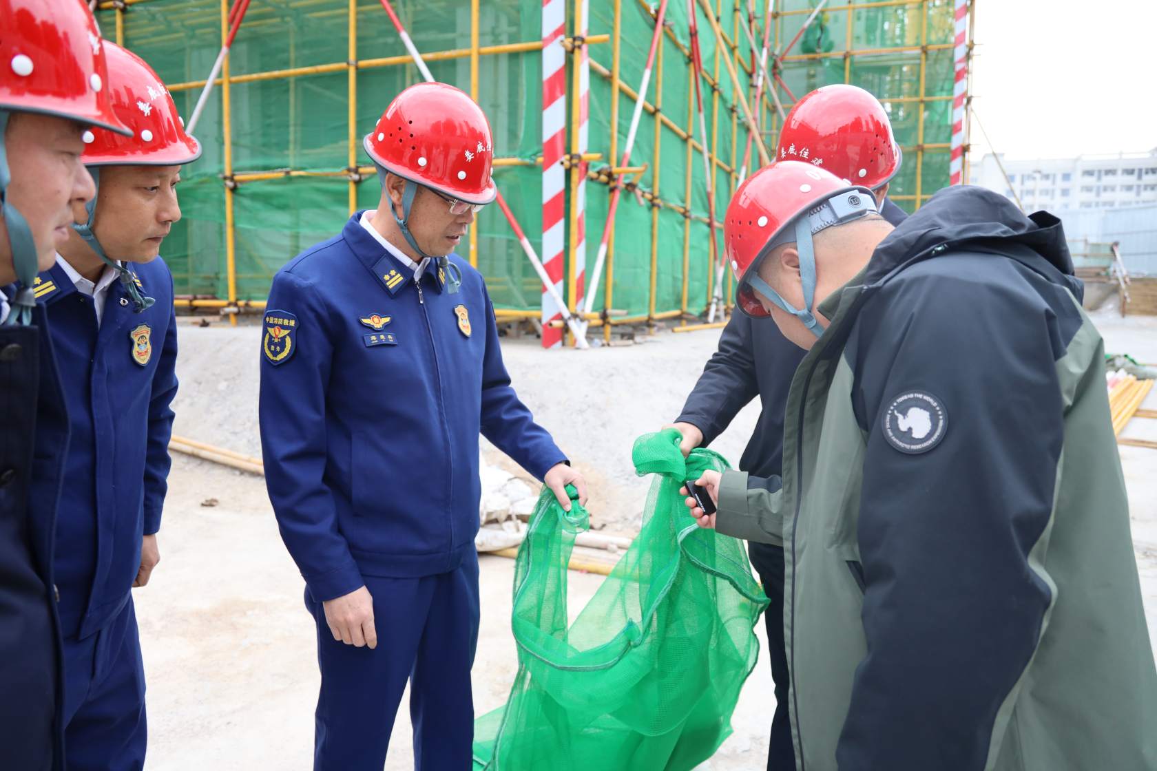 图为检查外脚手架防护网耐火等级（单位供图）