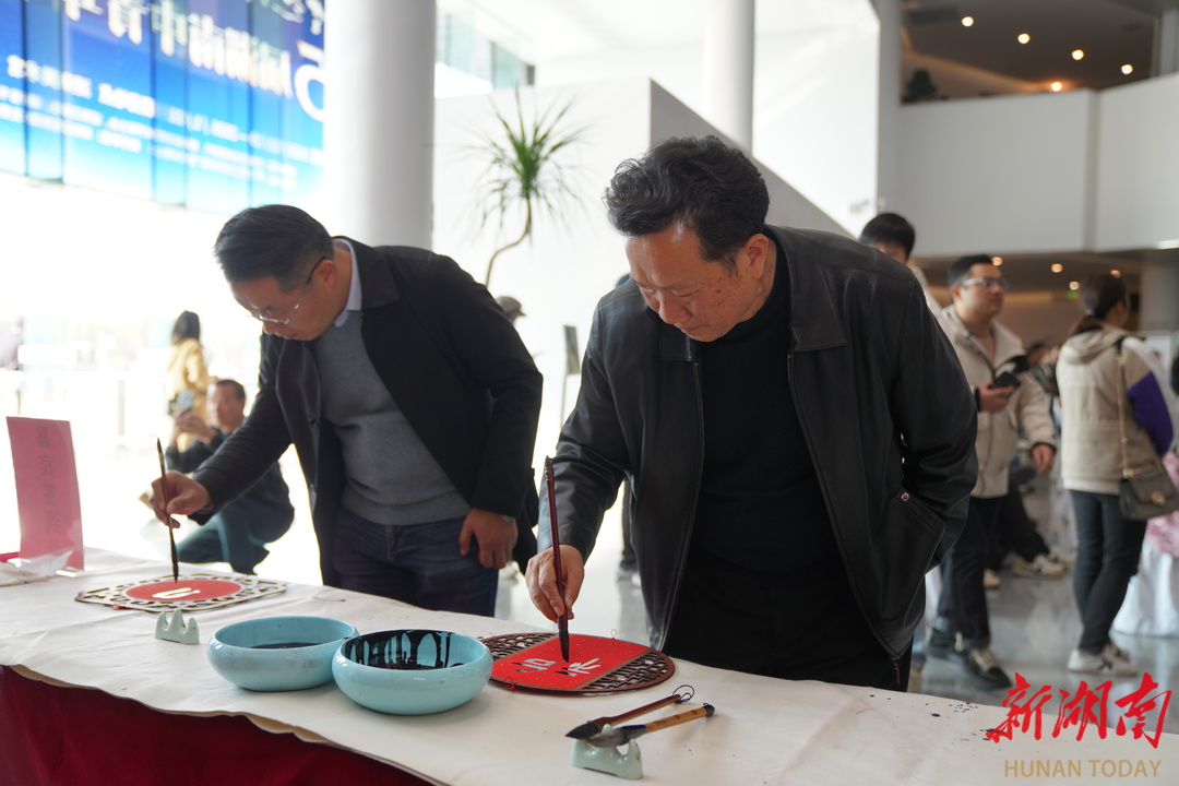 湖南省书法家协会副主席王希俊和湖南省书法家协会副主席伍剑写福。左观奇摄