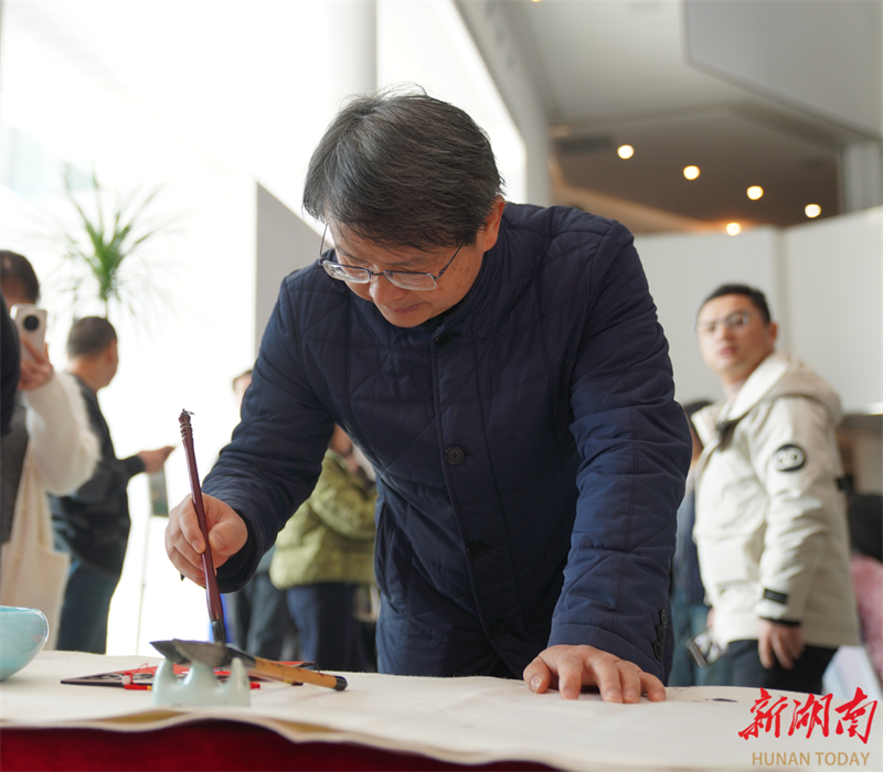 湖南省书法家协会副主席罗红胜书写祝福。左观奇摄