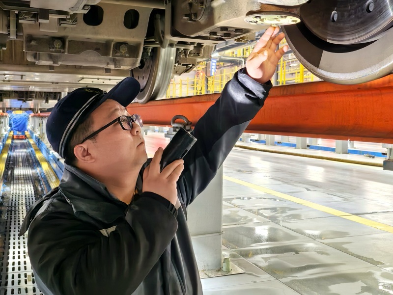 动车组机械师正在检查动车组走行部件。黄俊人摄