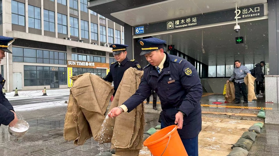 工作人员在车站出入口撒盐融雪、铺设麻袋。谭文雨摄