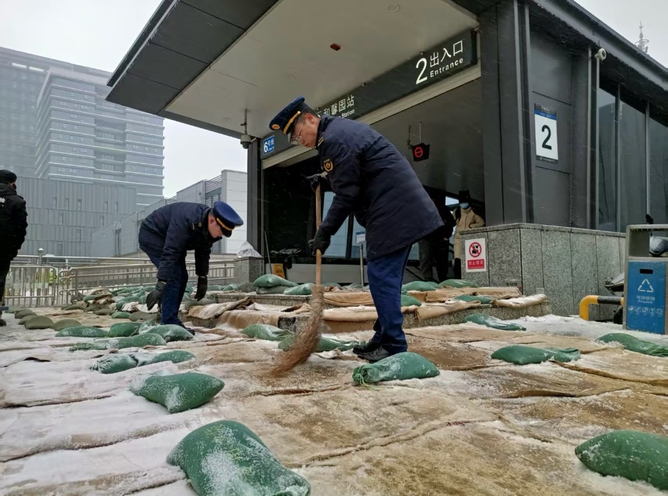 工作人员铺设麻袋、扫除冰雪。董扬浪 摄