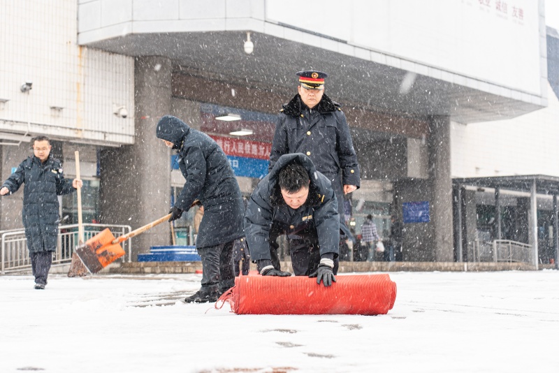 车站工作人员铺设防滑垫。受访单位供图