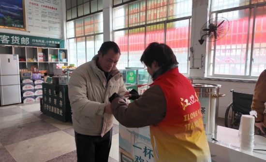 志愿者为旅客递上瑶茶瑶药。张雨摄
