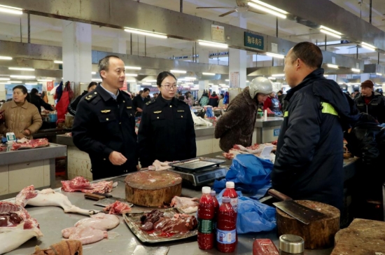 执法人员在农贸市场开展检查。周林凤摄