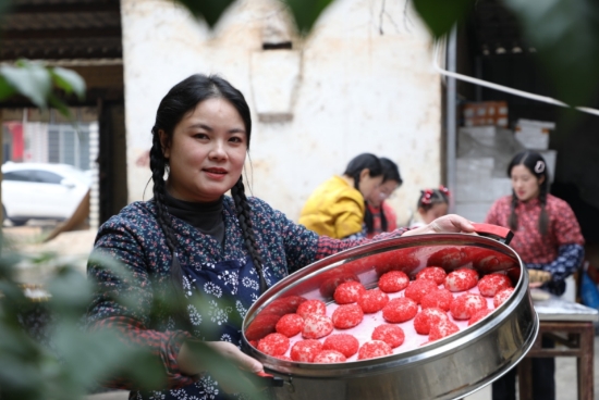展示剛裹好紅米的紅米粑粑。蔡興攝