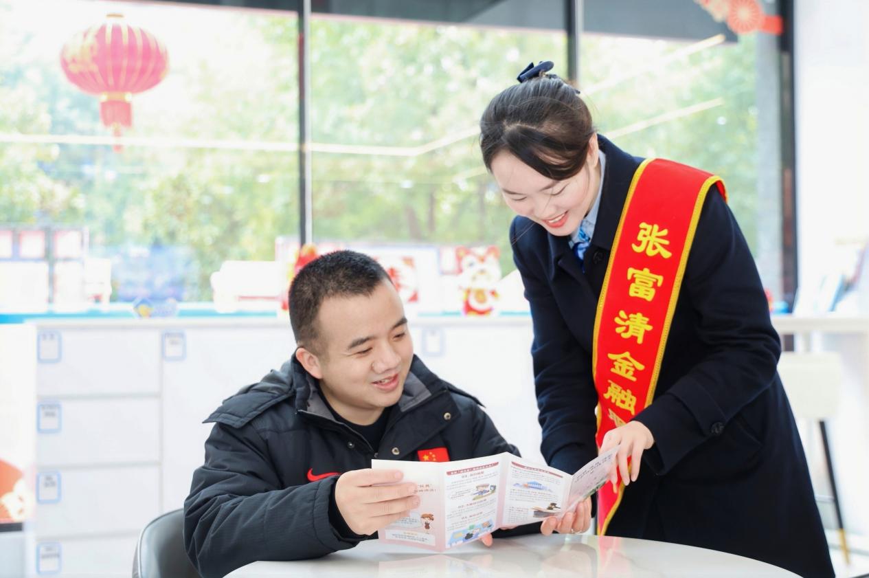 工作人員向市民講解反詐、反假知識。單位供圖