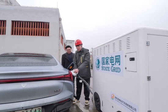 国网湖南电动汽车服务有限公司工作人员在巴陵服务区使用充电机器人为新能源车主充电。陈靖夫摄