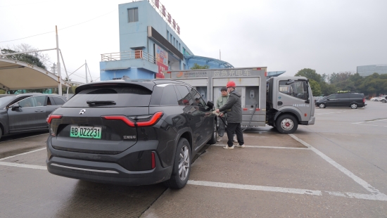 国网湖南电动汽车服务有限公司工作人员在巴陵服务区使用充电机器人为新能源车主充电。陈靖夫摄