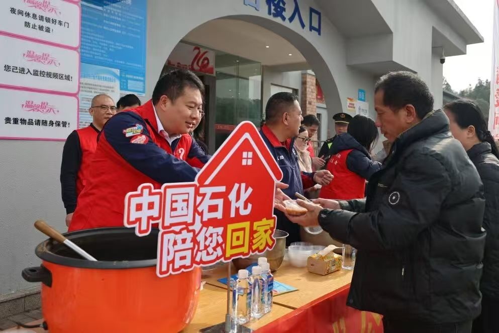 2月3日，长沙道林服务区，志愿者文涛为返乡游客送上八宝粥。 单位供图