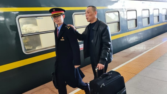 謝文井（右）搭著志願者的肩頭出站。受訪單位供圖