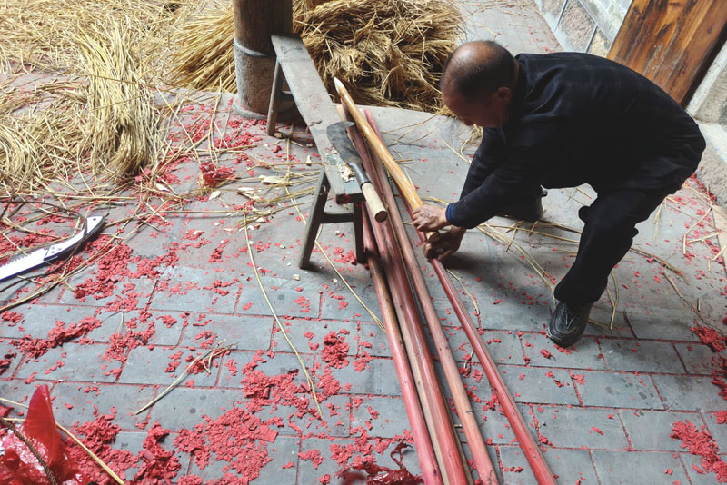 仔细比对制作龙棍。蒋淑芬摄