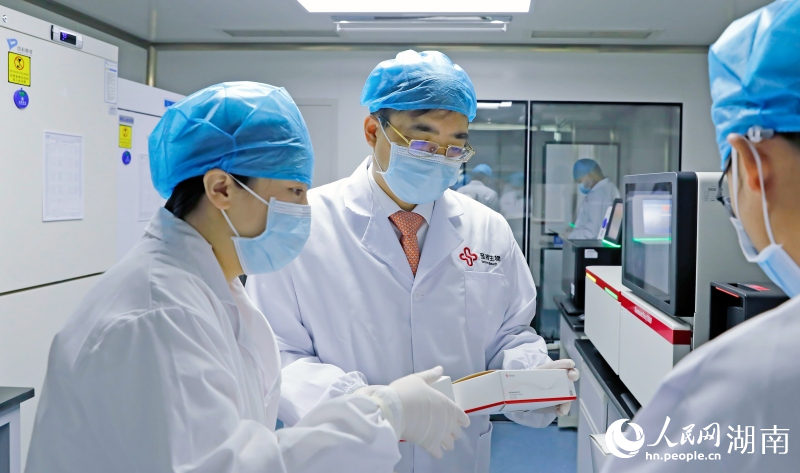 戴立忠（左二）與技術人員進行交流。人民網記者 林洛頫攝