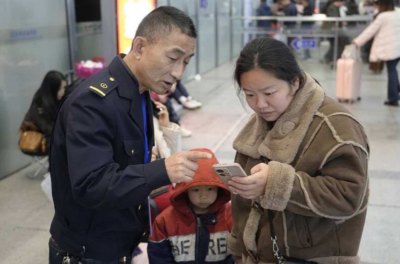 侯林德（左一）在日常工作中給旅客提供幫助。郭威攝