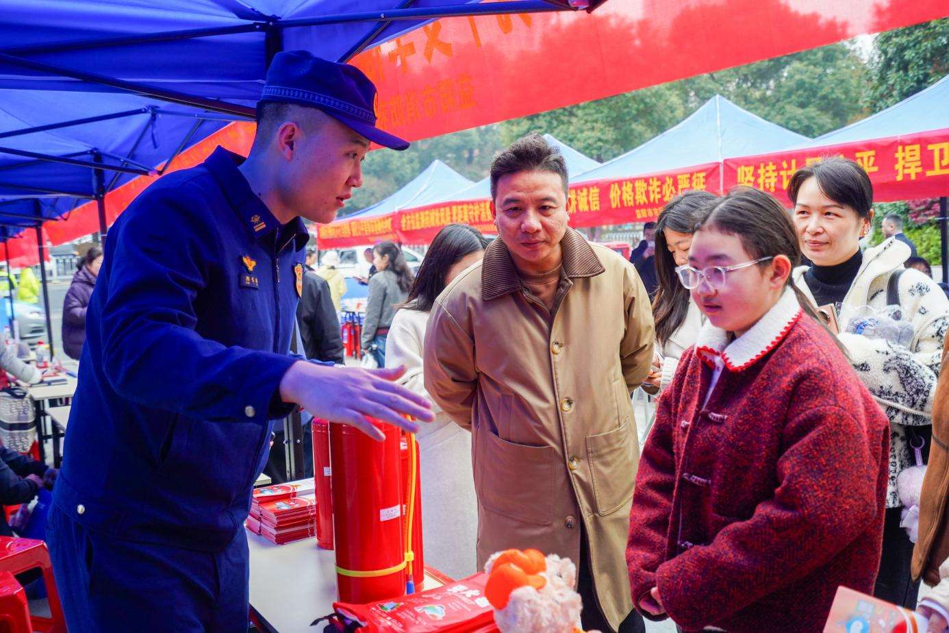 消防宣傳員向往來市民介紹如何辨別消防器材真偽（單位供圖）