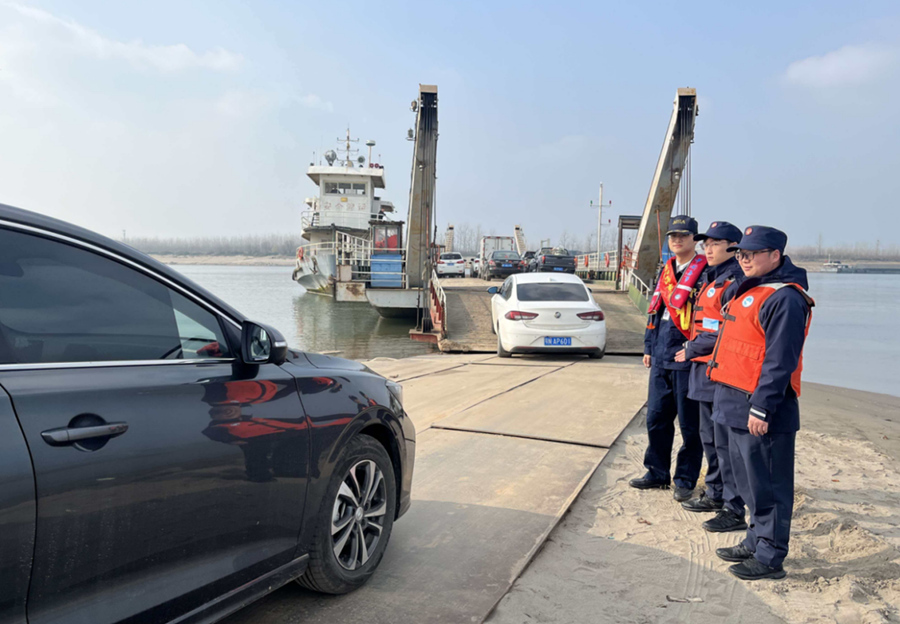 志愿者与工作人员护航车辆上轮渡。受访单位供图